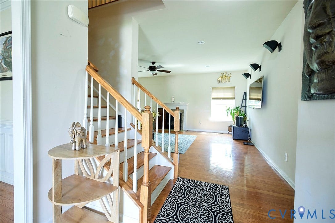 Hardwood flooring, painted white walls, wood staircase with white balusters, recessed lighting, and ceiling fan