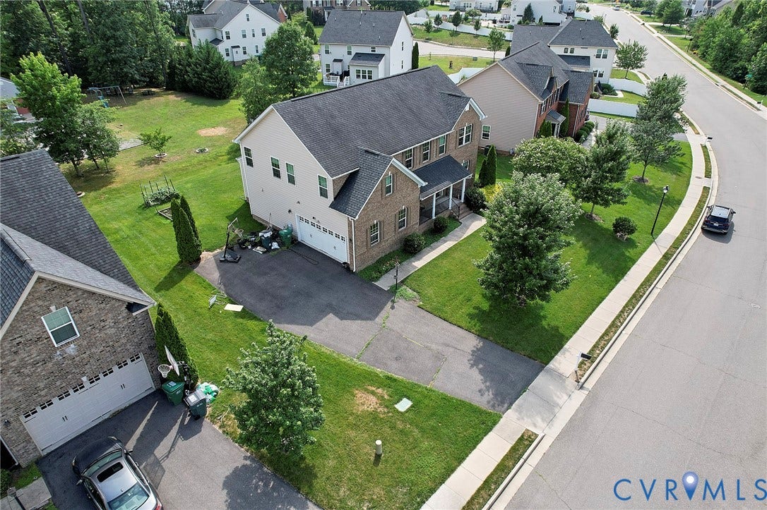 Two-story residence featuring a brick and siding exterior, front porch, two-car garage, and a paved driveway