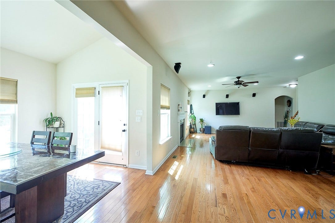 Hardwood flooring, vaulted ceiling, built-in fireplace, recessed lighting, and a ceiling fan