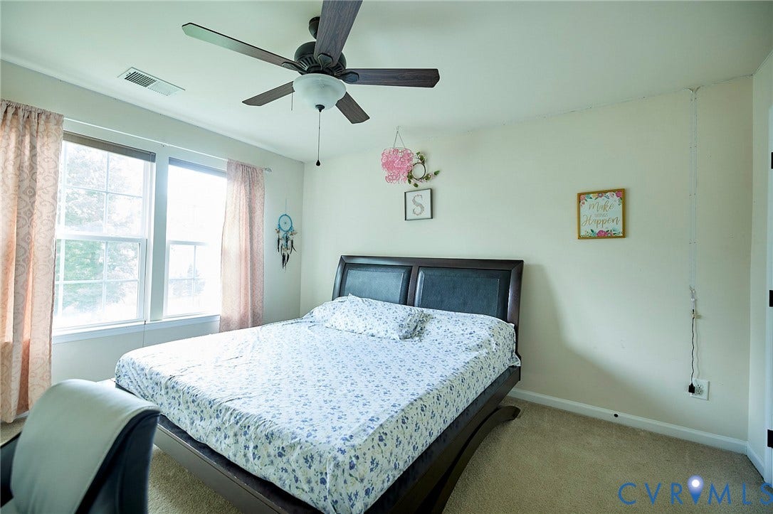 Carpeted flooring with a ceiling fan and light fixture