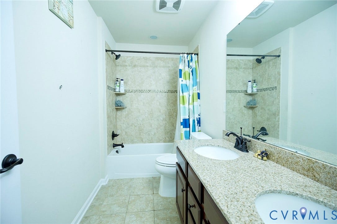 Dual vanity with integrated sinks, granite countertop, and dark wood-finish cabinetry