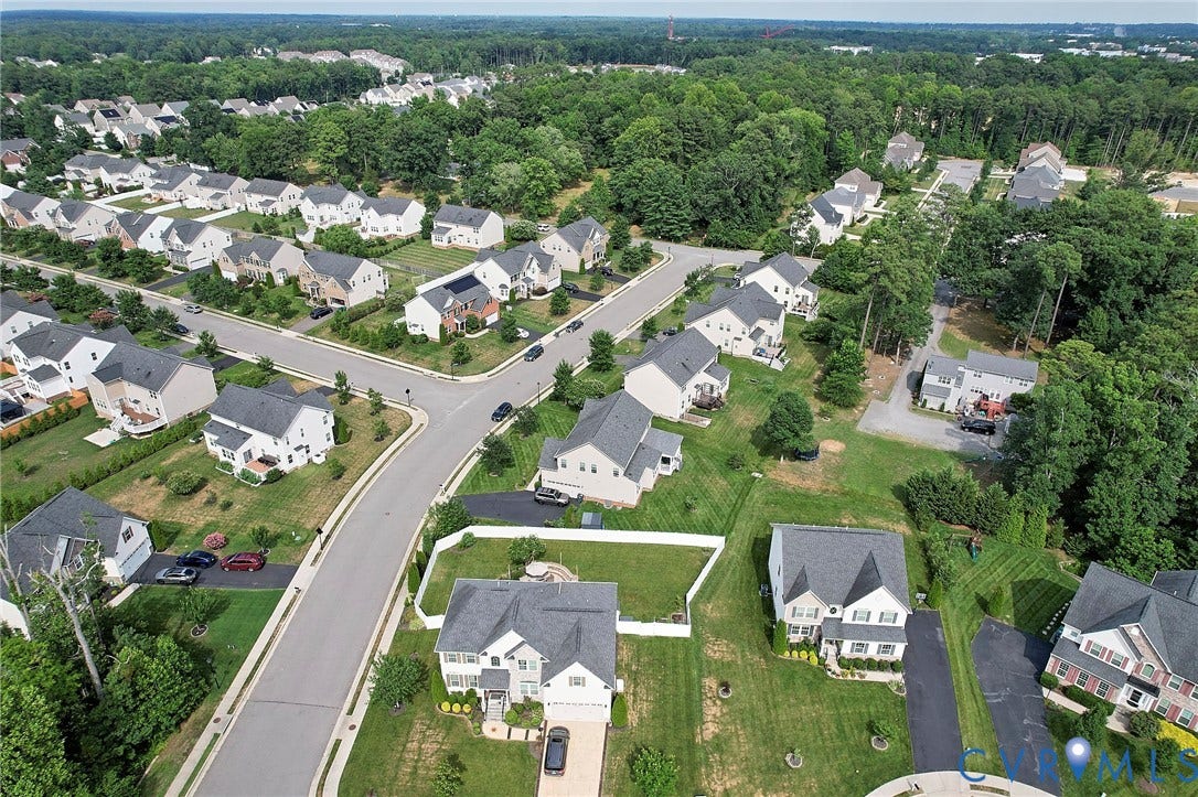 Residential neighborhood featuring detached homes with gabled roofs and manicured lawns