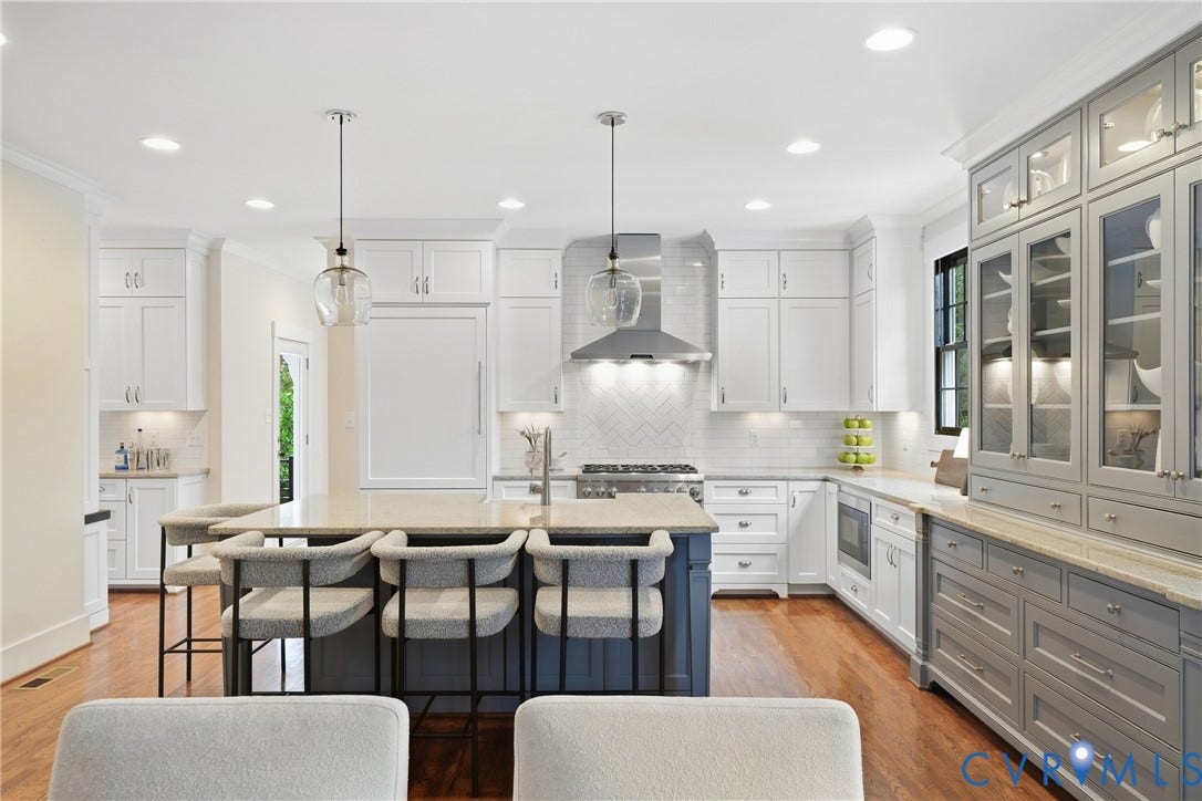 Gourmet kitchen featuring a central island, recessed lighting, hardwood flooring, white shaker cabinetry, and a full suite of stainless steel appliances