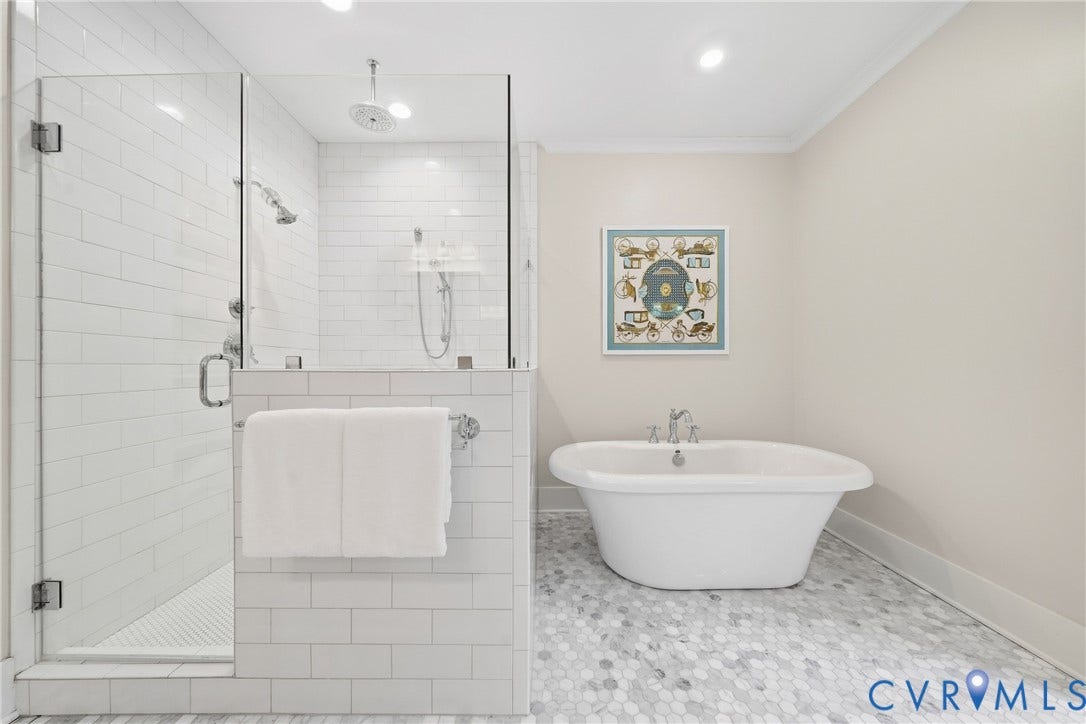 Freestanding soaking tub, glass-enclosed shower with subway tile, dual shower heads, recessed lighting, and hexagon tile flooring