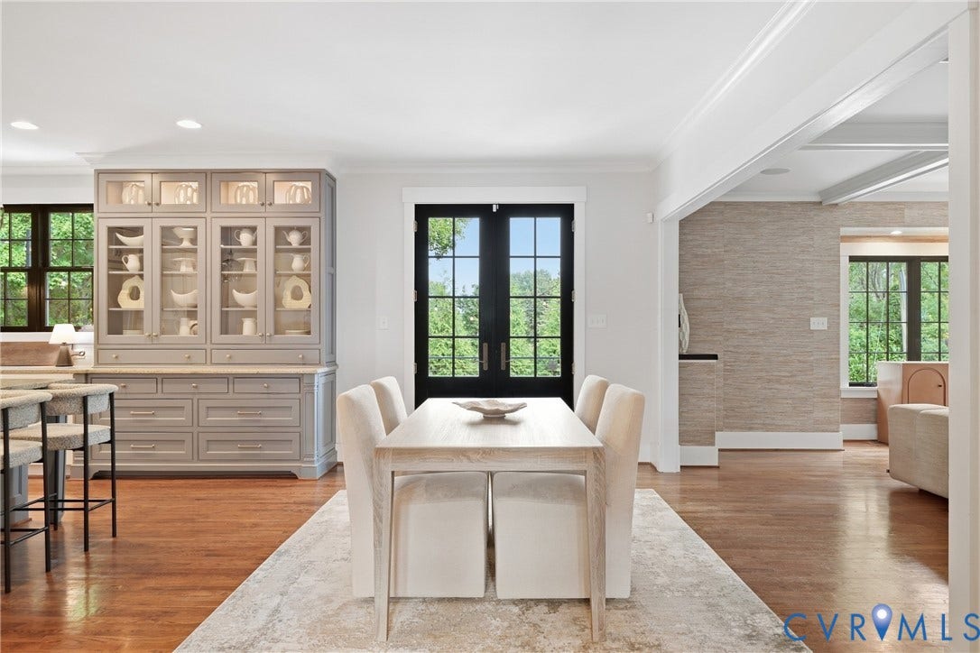 Hardwood flooring throughout, built-in cabinetry with glass display, recessed lighting, and black framed French doors