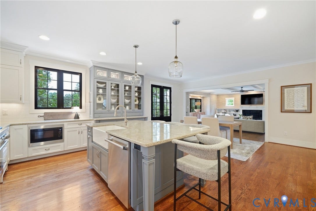 Kitchen featuring a central island with countertop seating, a farmhouse sink, and pendant lighting