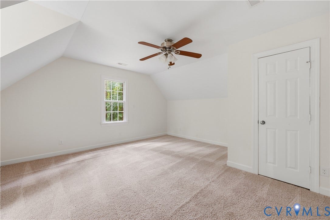 Vaulted ceilings with a ceiling fan, window with grid panes, and a six-panel door