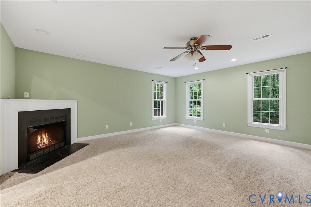 Fireplace with a white mantel, ceiling fan, recessed lighting, and multiple windows