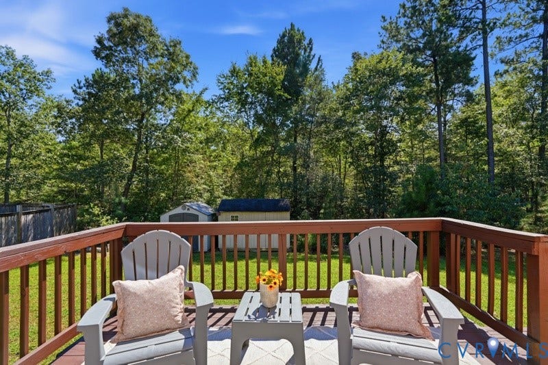 6012 Regal Crest Drive, Kings Grove, Chesterfield, VA 23832 Expansive wood-finish deck with a wood railing, overlooking a fenced backyard with a storage shed and mature trees