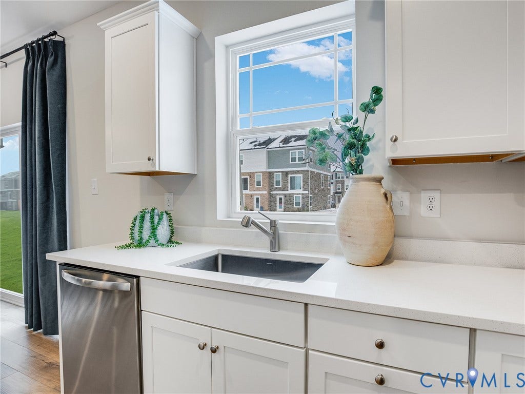 3724 Larimar Lane, Everstone, Richmond, VA 23223 White shaker cabinetry, stainless steel dishwasher, undermount sink with a gooseneck faucet, light-toned countertops, and wood-finish flooring
