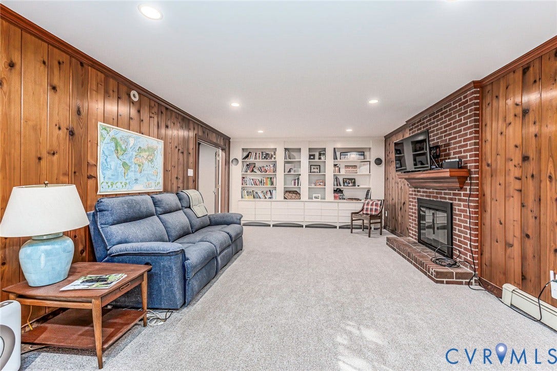 10309 Collinwood Drive, Henrico, VA 23238 Basement with new carpet (2026), recessed lighting, built-in shelving and brick wood burning fireplace.