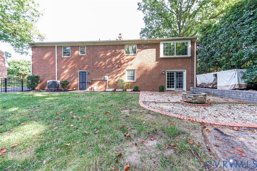 10309 Collinwood Drive, Henrico, VA 23238 Rear view with brick exterior, sliding glass door to basement, paver patio with fire pit