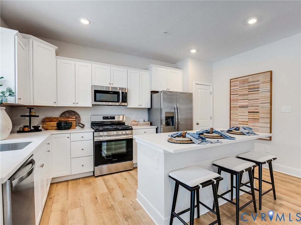 3712 Larimar Lane, Everstone, Richmond, VA 23222 Kitchen featuring white cabinetry, stainless steel appliances, light-toned wood-finish flooring, recessed lighting, and a kitchen island with seating