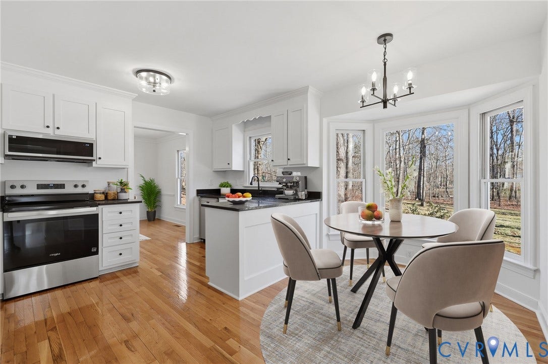 3264 Sherwood Ridge Way, Powhatan, VA 23139 Wood-finish flooring throughout, modern chandelier, crown molding, chair rail molding, and built-in cabinetry with a dark countertop