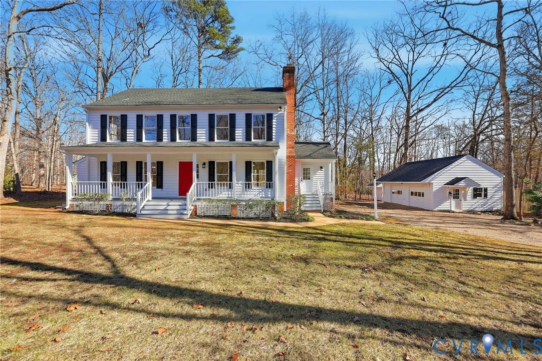 3264 Sherwood Ridge Way, Powhatan, VA 23139 White siding exterior with a dark shingle roof, featuring two garage doors with window inserts, and a separate entry door with a decorative overhang