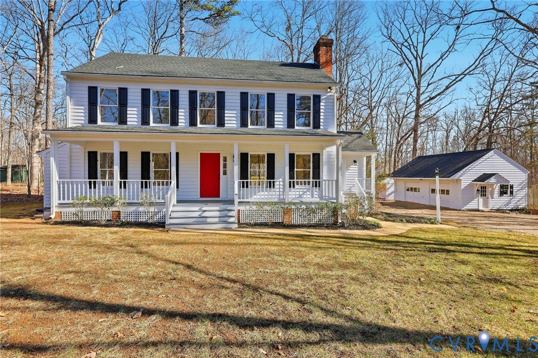 3264 Sherwood Ridge Way, Powhatan, VA 23139 Two-story residence with a covered front porch, a vibrant red front door, and a detached multi-car garage