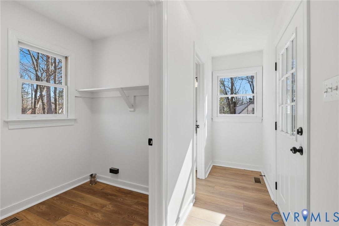 3264 Sherwood Ridge Way, Powhatan, VA 23139 Wood-finish flooring throughout, white walls, built-in shelving, white trim window, and a white paneled door with dark hardware