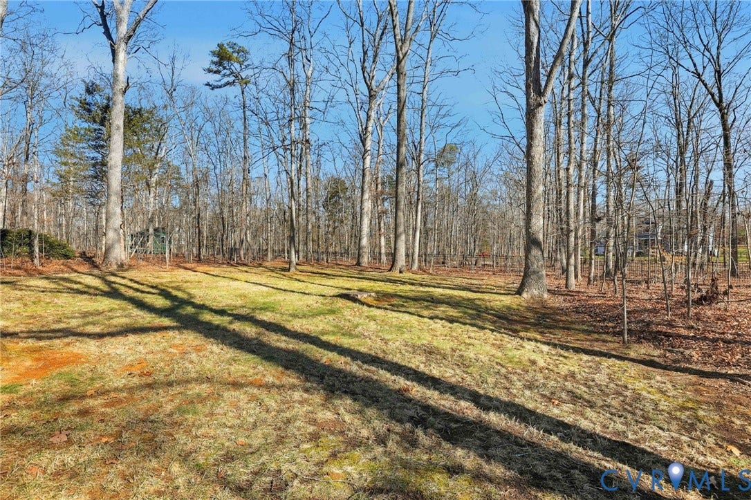 3264 Sherwood Ridge Way, Powhatan, VA 23139 White siding exterior with a brick foundation, a wood deck with stairs, a bay window, and a brick chimney