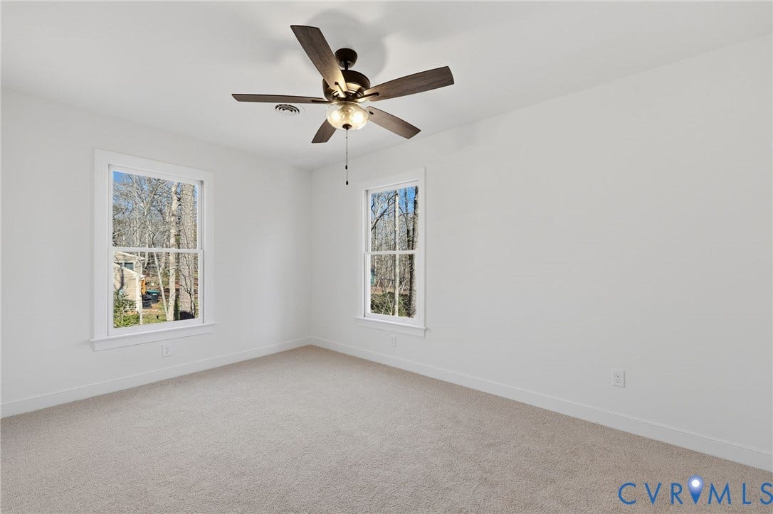 3264 Sherwood Ridge Way, Powhatan, VA 23139 Light-colored carpeting, white walls, bi-fold closet doors, and a ceiling fan with integrated lighting
