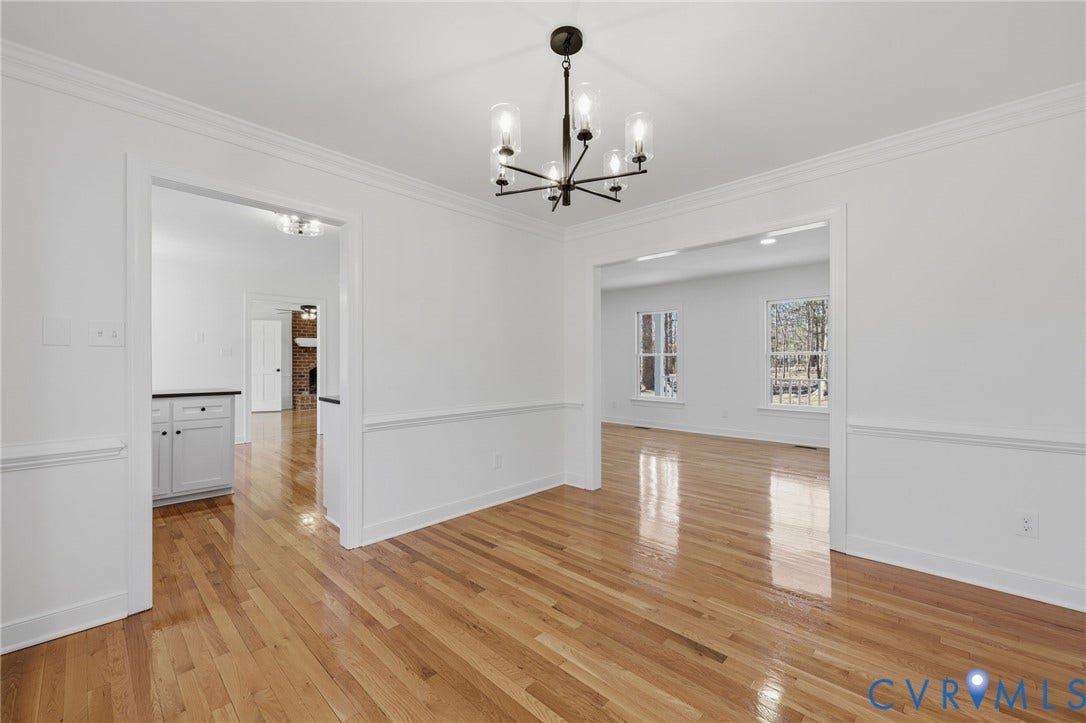 3264 Sherwood Ridge Way, Powhatan, VA 23139 White cabinetry with black hardware, wood-finish flooring, stainless steel appliances, black countertops, and a ceiling-mounted light fixture