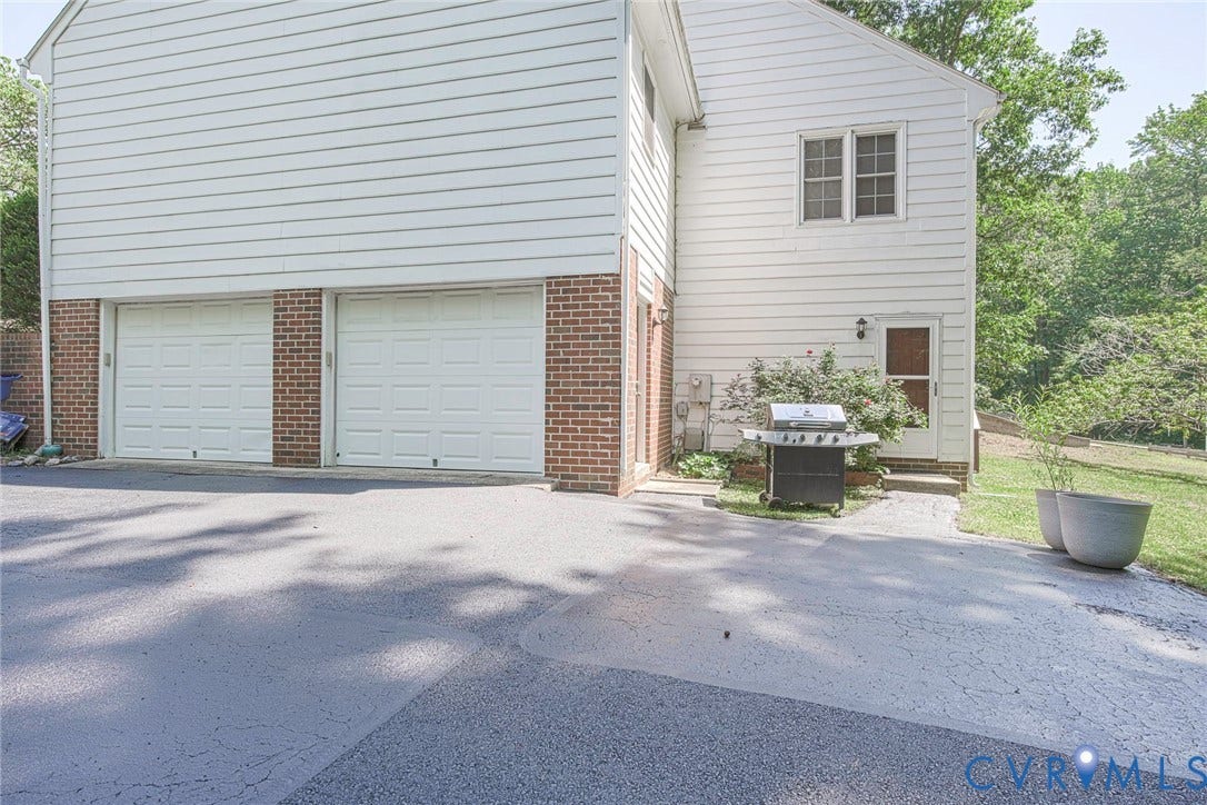 Two-car garage with white panel doors and brick accents