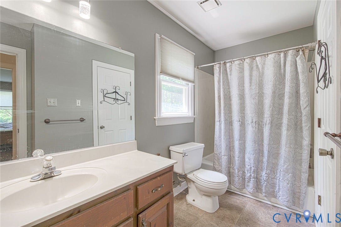 Vanity with integrated sink, white countertop, and wood-finish cabinetry
