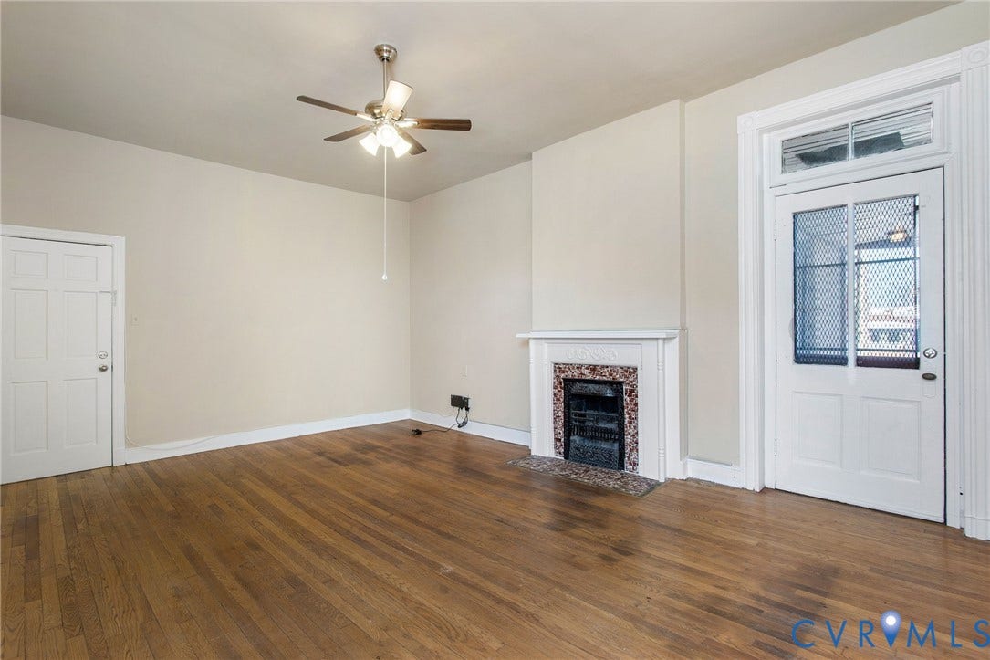 2604 Grove, #5, Richmond, VA 23220 Wood-finish flooring, ceiling fan with integrated lighting, decorative fireplace with stone surround, and a paneled door with transom window