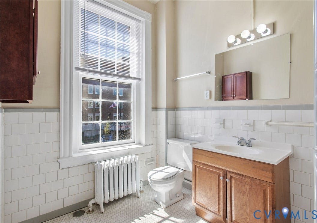 2604 Grove, #5, Richmond, VA 23220 White subway tile wainscoting, hex tile flooring, wood-finish vanity with white countertop, chrome fixtures, and a large window