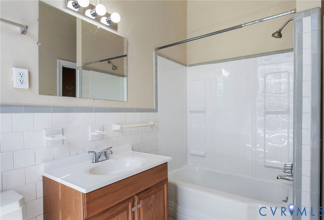 2604 Grove, #5, Richmond, VA 23220 Bathroom featuring a wood-finish vanity, integrated sink, and white tile wainscoting