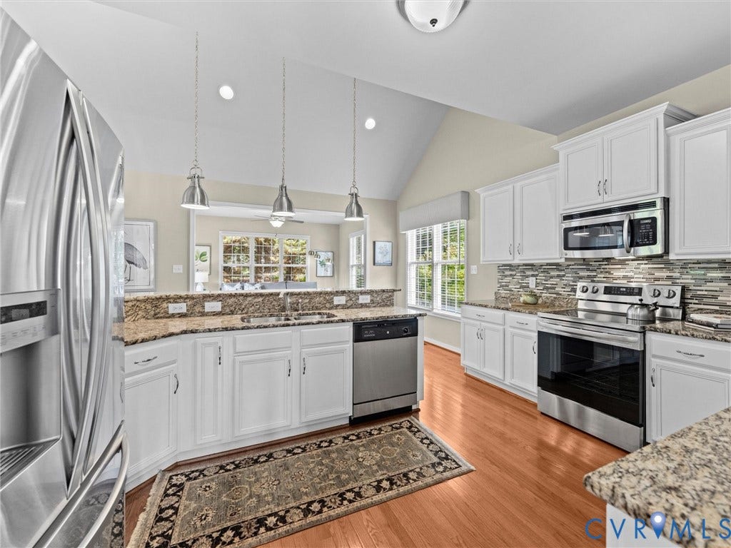 1663 Centerville Parke Lane, The Parke At Centerville, Manakin Sabot, VA 23103 Vaulted ceiling with recessed lighting, white cabinetry, stainless steel appliances, granite countertops, and wood-finish flooring