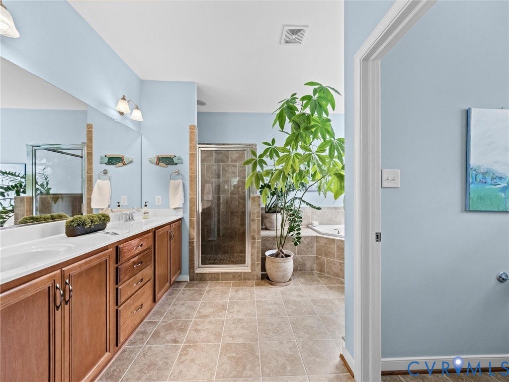 1663 Centerville Parke Lane, The Parke At Centerville, Manakin Sabot, VA 23103 Double vanity with wood-finish cabinetry, a glass-enclosed shower, a built-in soaking tub, and tile flooring