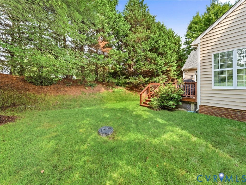 1663 Centerville Parke Lane, The Parke At Centerville, Manakin Sabot, VA 23103 Expansive grassy yard with mature trees, wood deck, and wood siding