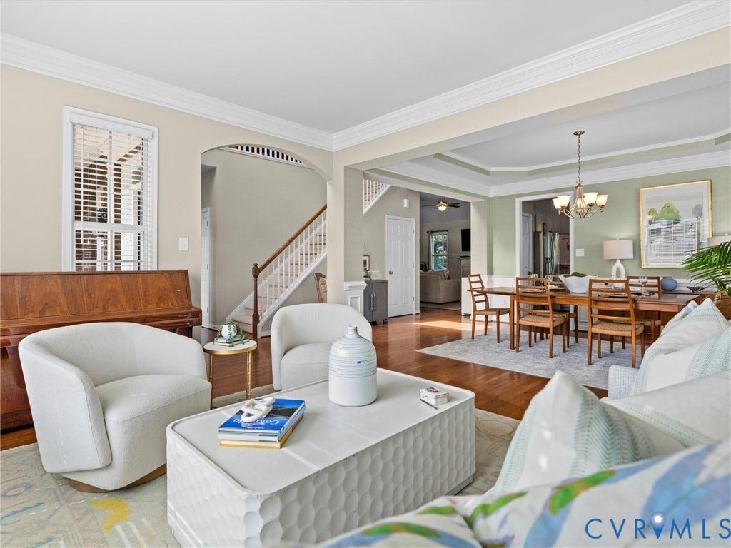 1663 Centerville Parke Lane, The Parke At Centerville, Manakin Sabot, VA 23103 Hardwood flooring, crown molding, arched entryways, a tray ceiling, and a chandelier in the dining area
