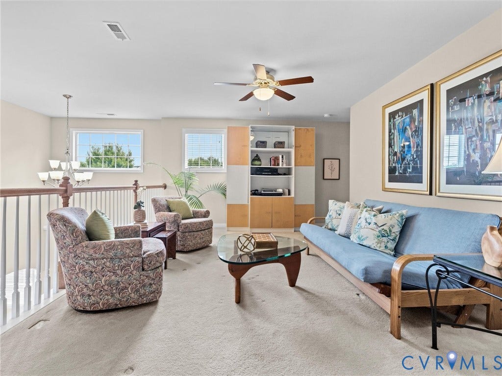 1663 Centerville Parke Lane, The Parke At Centerville, Manakin Sabot, VA 23103 Open loft area featuring a ceiling fan, built-in shelving, white baluster railing, and natural light from multiple windows