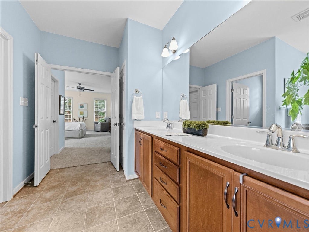 1663 Centerville Parke Lane, The Parke At Centerville, Manakin Sabot, VA 23103 Dual vanity with integrated sinks, wood-finish cabinetry, and a large wall-mounted mirror