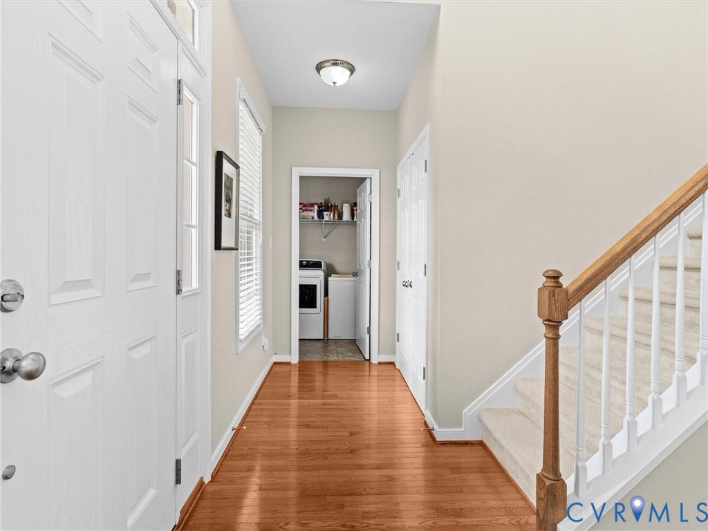 1663 Centerville Parke Lane, The Parke At Centerville, Manakin Sabot, VA 23103 Hardwood-finish flooring extending through the entry, white paneled entry door with sidelight, and carpeted staircase with wood handrail and white balusters