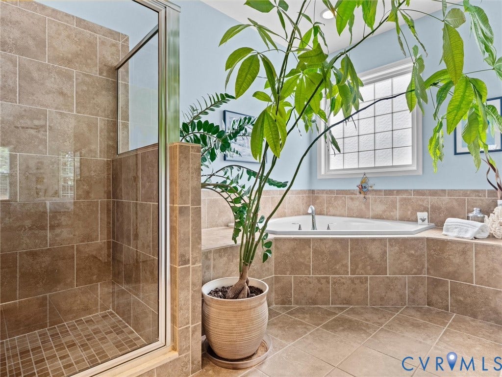 1663 Centerville Parke Lane, The Parke At Centerville, Manakin Sabot, VA 23103 Tiled flooring with a corner soaking tub and an enclosed shower featuring a glass door