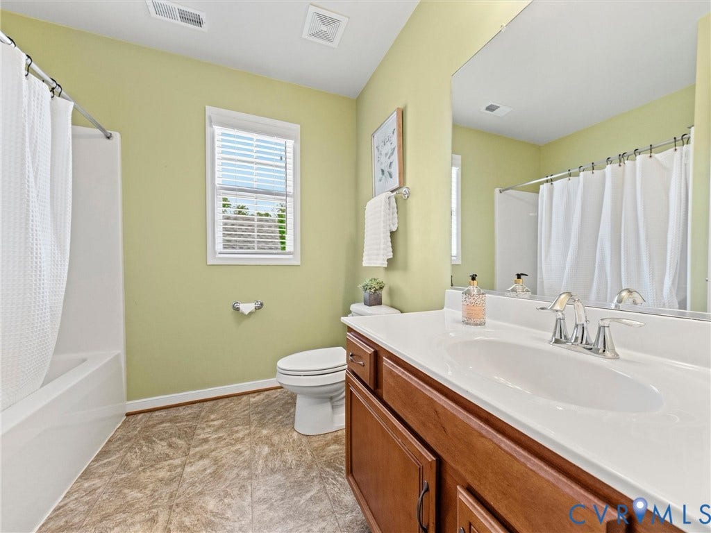 1663 Centerville Parke Lane, The Parke At Centerville, Manakin Sabot, VA 23103 Bathroom featuring a built-in shower/tub combination, single window, vanity with an integrated sink, and wood-finish cabinetry