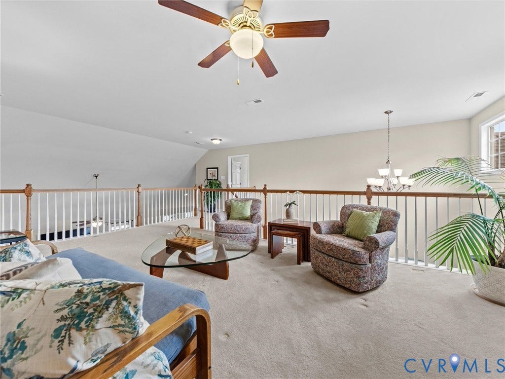 1663 Centerville Parke Lane, The Parke At Centerville, Manakin Sabot, VA 23103 Carpeted loft area featuring a ceiling fan, white railing with wood-finish top rail, and a multi-light chandelier