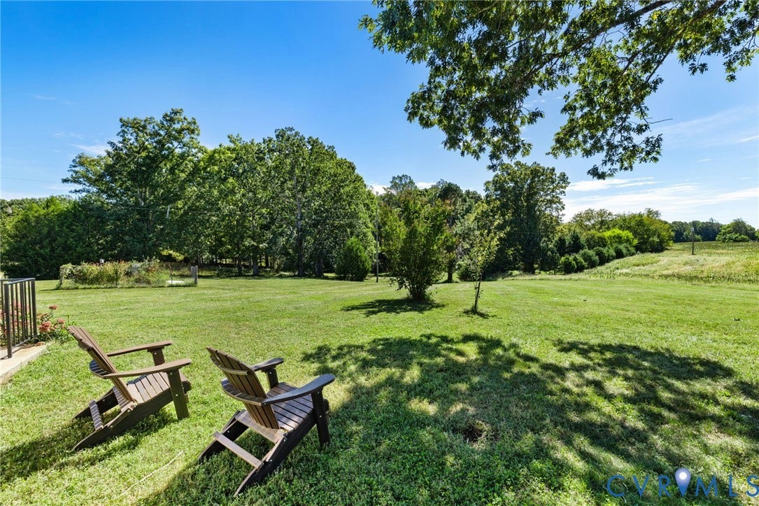 4109 Whitehall Road, Sandy Hook, VA 23153 Expansive grassy lawn with surrounding mature trees and a clear blue sky