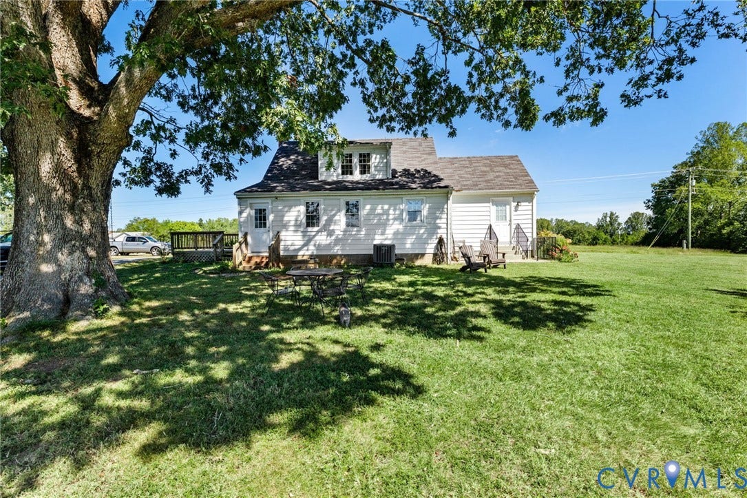 4109 Whitehall Road, Sandy Hook, VA 23153 Expansive grassy yard with a mature shade tree, rear deck, and dormer windows on the white siding exterior