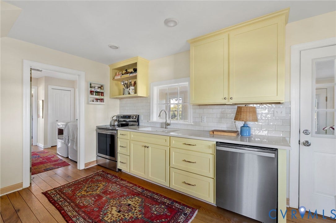 4109 Whitehall Road, Sandy Hook, VA 23153 Kitchen featuring light yellow cabinetry, stainless steel appliances, a white subway tile backsplash, and wood-finish flooring