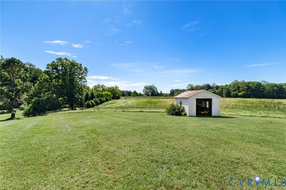 4109 Whitehall Road, Sandy Hook, VA 23153 Expansive grassy grounds with a detached storage shed, framed by mature trees and natural landscaping