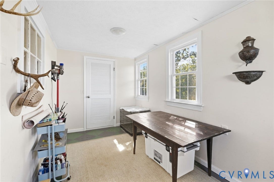 4109 Whitehall Road, Sandy Hook, VA 23153 White painted walls, multiple single-hung windows, a white louvered door, a flush-mount ceiling light fixture, and crown molding