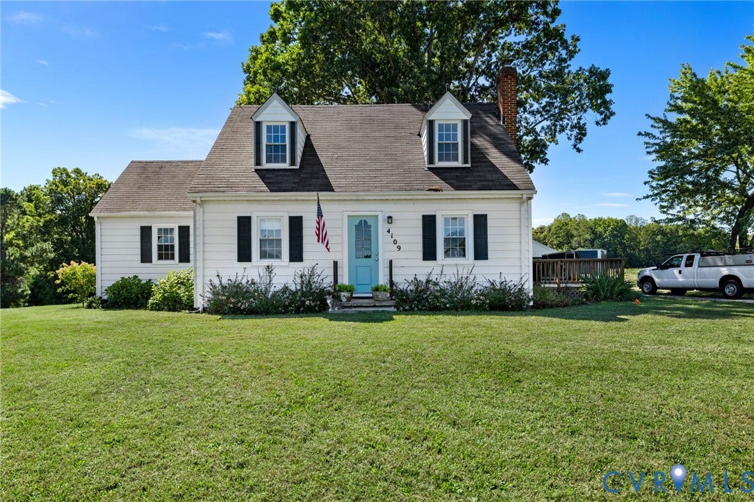 4109 Whitehall Road, Sandy Hook, VA 23153 White exterior with black shutters, dormer windows, a light blue front door, and a side deck