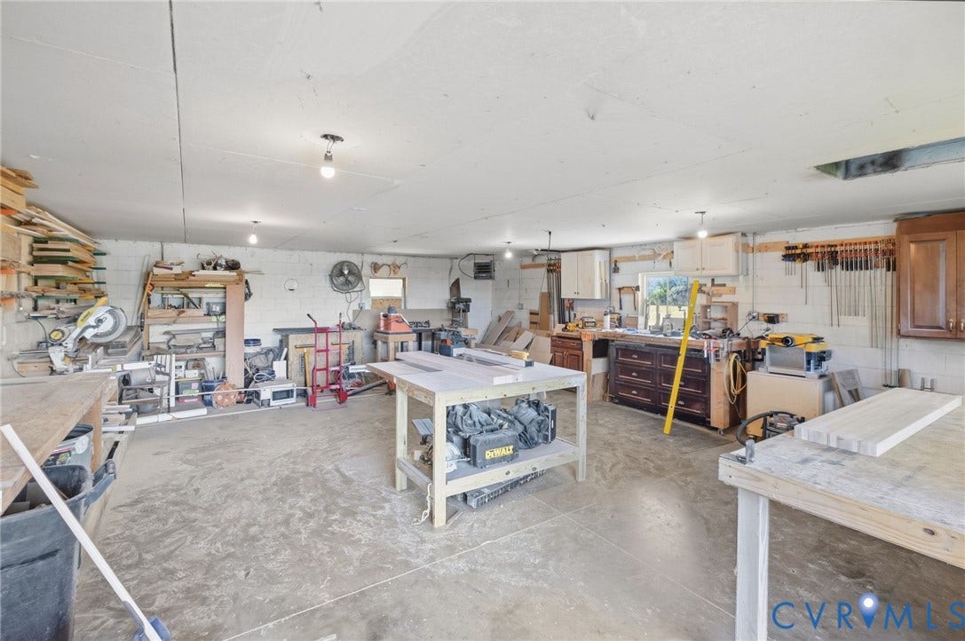 4109 Whitehall Road, Sandy Hook, VA 23153 Spacious workshop featuring a concrete floor, built-in cabinetry, and multiple workbenches