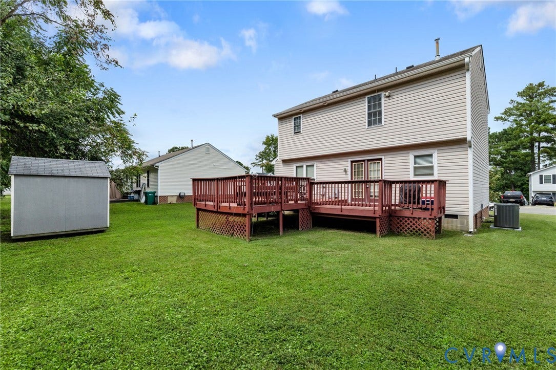 1429 Almondberry Place, Henrico, VA 23231 Expansive backyard featuring a stained wood deck, a storage shed with a shingled roof, and a mature tree