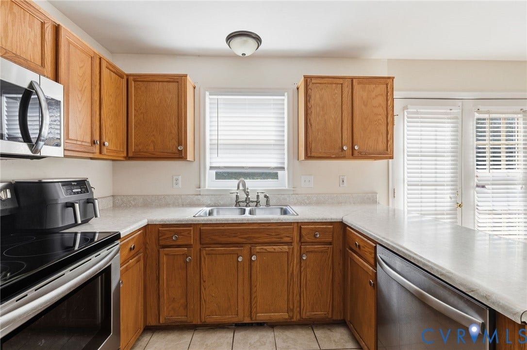 1429 Almondberry Place, Henrico, VA 23231 Kitchen featuring wood cabinetry, stainless steel appliances, a double basin sink, light-toned countertops, and tile flooring