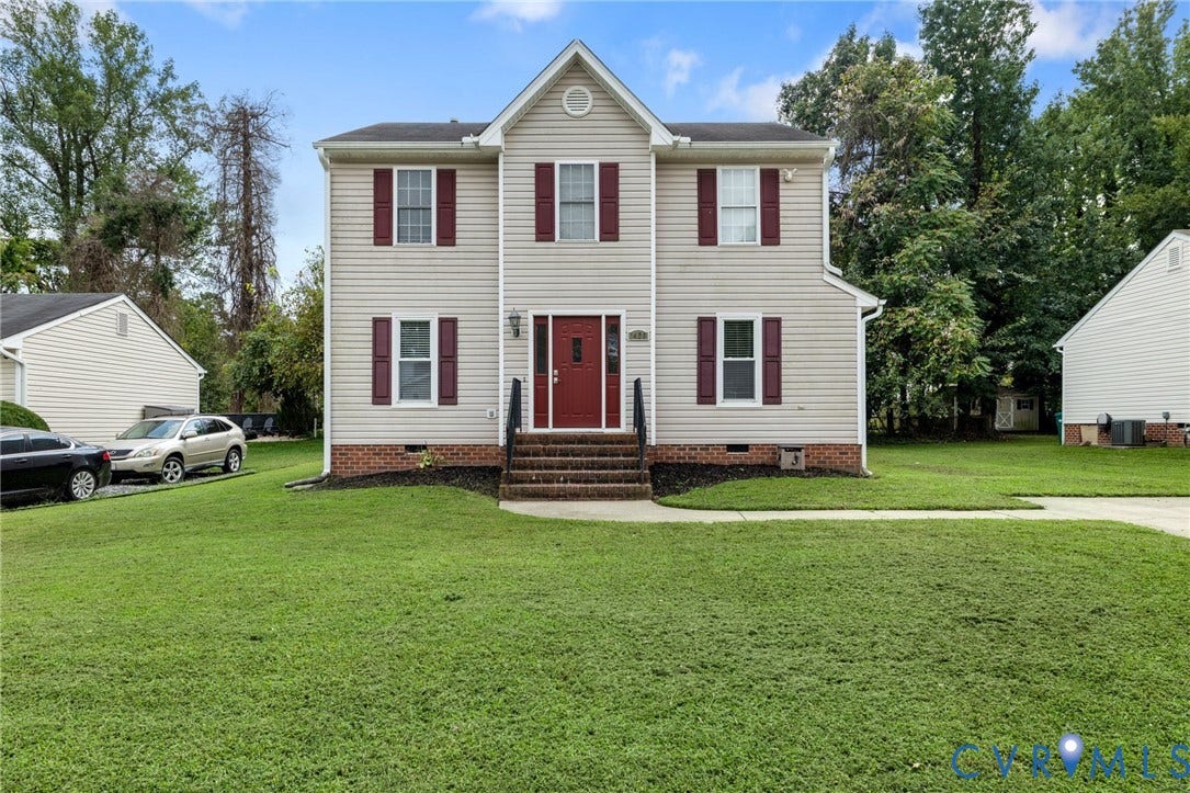 1429 Almondberry Place, Henrico, VA 23231 Two-story exterior with light-colored siding, contrasting dark shutters, a prominent red front door, and a spacious green lawn