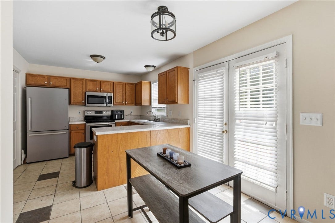 1429 Almondberry Place, Henrico, VA 23231 Kitchen featuring wood-finish cabinetry, stainless steel appliances, light-toned countertops, and patterned tile flooring